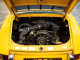 a yellow car with a engine in the trunk of it