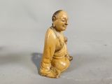 two figurines of a man and a woman sitting on the ground