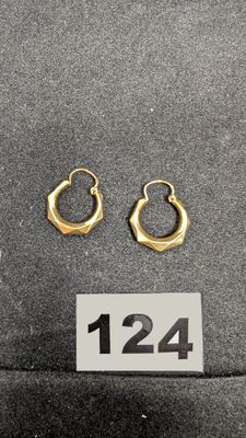 deux paires de boucles d'oreilles créoles en or posées sur une surface noire