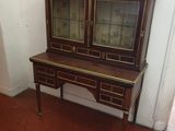 une armoire en bois surmontée de portes vitrées