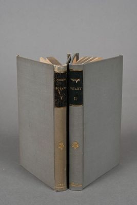 an open book sitting on top of a table next to another book