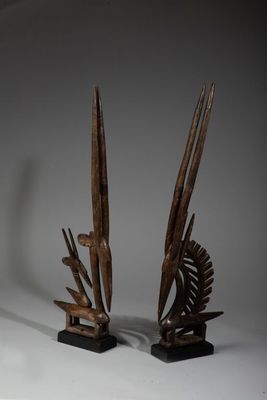 paire de sculptures en bois sculpté représentant des oiseaux et un poisson, posées sur un socle