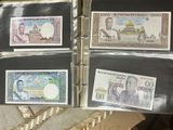 four different bank notes are in a binder on a table