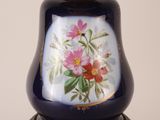 a blue vase with flowers painted on it on a table