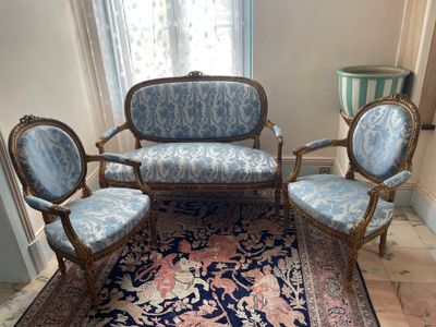 three chairs and a couch in a room with a rug on the floor