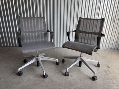 une paire de chaises de bureau à roulettes devant un mur en tôle ondulée