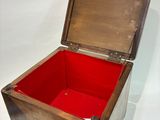 a wooden box with a red lid sitting on a white surface