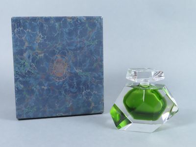 un flacon de parfum posé à côté d'une boîte sur une table