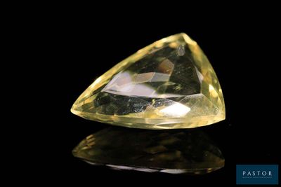 a close up of a yellow diamond on a black surface