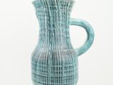 a blue vase that is sitting on a white surface