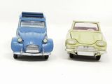 two toy cars sitting next to each other on a white surface