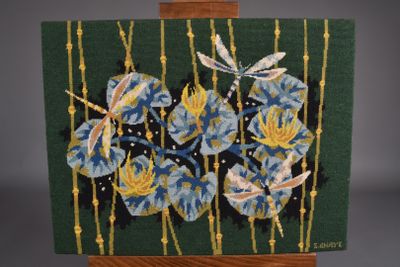 une image représentant une broderie de fleurs bleues sur fond vert
