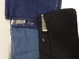 three pairs of levi ' s jeans sitting on top of each other