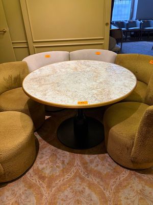 une table ronde entourée de chaises dans une pièce