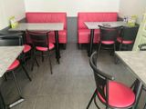 tables and chairs are lined up in a restaurant with red seats