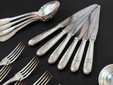 a lot of silver spoons and forks on the table