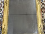 une photo d'un miroir à cadre doré posé sur un tapis