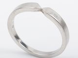 a close up of a silver ring with a curved band
