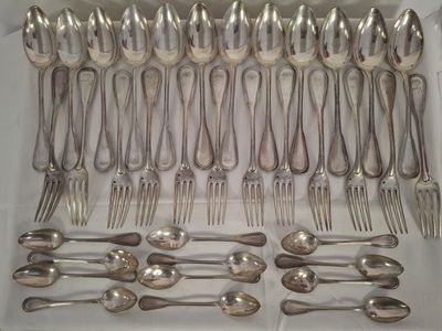 un lot de cuillères et fourchettes en argent dans une boîte