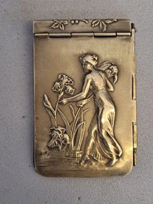 a gold plated picture of a woman with flowers on it