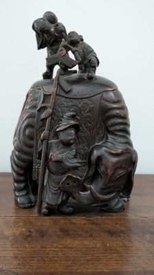 a statue of a man riding an elephant with a child on its back