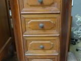 une petite commode en bois dans un coin de la pièce