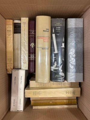 many books in a box that are stacked together