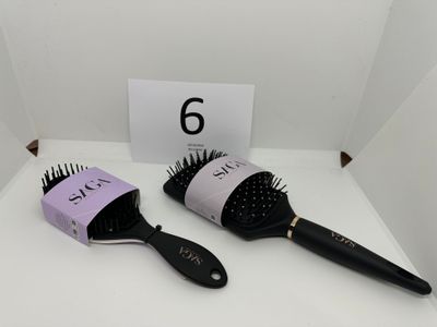 two hair brushes sitting on a table next to each other