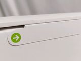 a close up of a white refrigerator with a green arrow on it