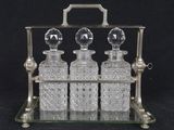 an image of a set of three glass decanters on a metal stand