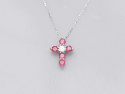 un pendentif en forme de croix, orné de diamants roses et blancs, monté sur une chaîne en argent