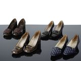Quatre paires de chaussures pour femmes sont alignées sur une surface noire