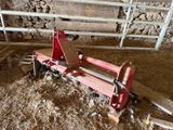 a red machine that is sitting in the hay