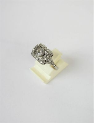 a close up of a diamond ring on a white surface