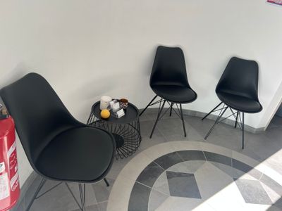 three black chairs in the corner of a room