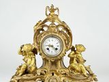 a gold clock with cherensils on it on a white background