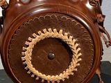 a wooden clock with a decorative design on it