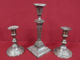 trois bougeoirs en argent sur fond rouge, avec un fond rouge