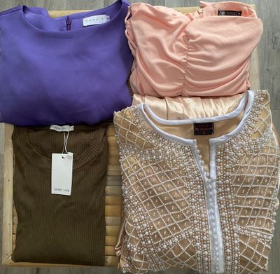 three women ' s clothing sitting on a chair on a wooden floor
