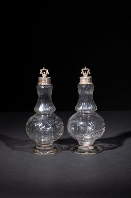two clear glass salt and pepper shakers on a black surface