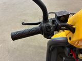 a close up of the handlebars on a yellow motorcycle
