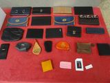 de nombreux modèles différents de sacs à main et de portefeuilles disposés sur une table rouge