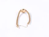 a close up of a gold chain bracelet on a white background