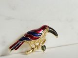 a bird brooch that is sitting on a white surface