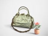sac à main vert avec une chaîne et une fleur en pot sur fond blanc