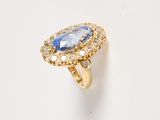 a close up of a gold ring with a tan sapphire and white diamonds