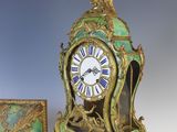 a green and gold clock sitting next to a small box