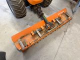 a tractor with a plow attached to it ' s front wheel