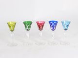 four different colored wine glasses are lined up in a row