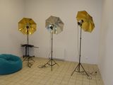 trois parapluies dans un coin de la pièce, près d'un pouf bleu